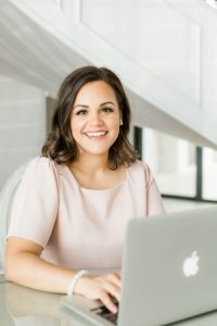 Woman sitting at desk typing on laptop